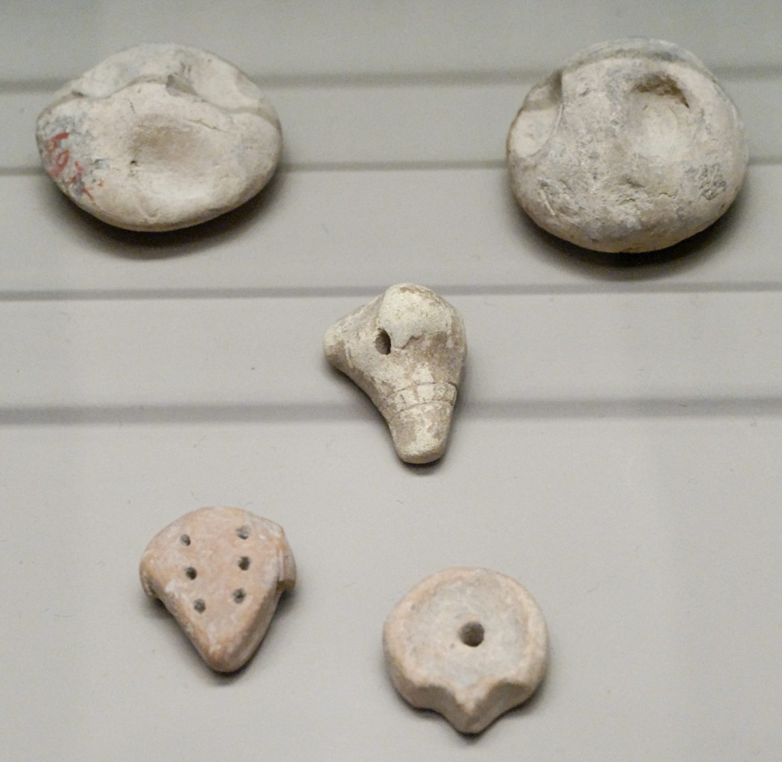 Five clay accounting tokens of different shapes, cones, spheres and discs, from Susa